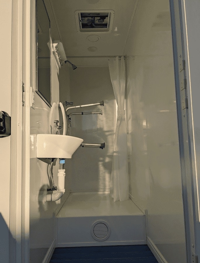 Compact bathroom with shower and sink.