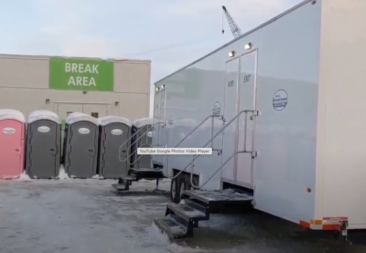 Portable toilets beside a mobile break area.