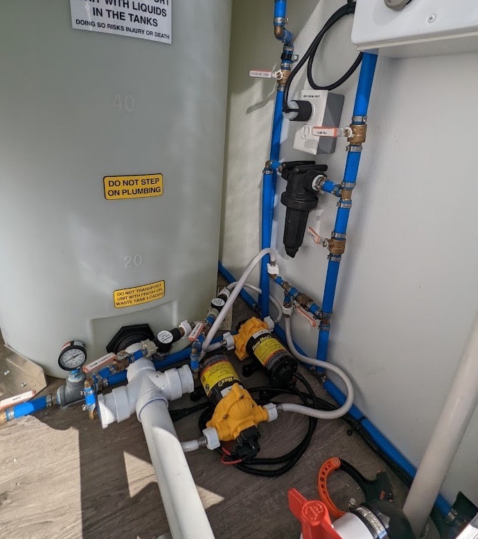 Industrial water filtration system with pipes and warning labels.