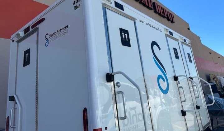 Service restroom trailers parked outside a business.