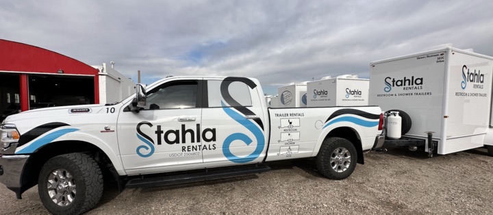 Stahla Rentals branded truck with attached portable restroom trailer.