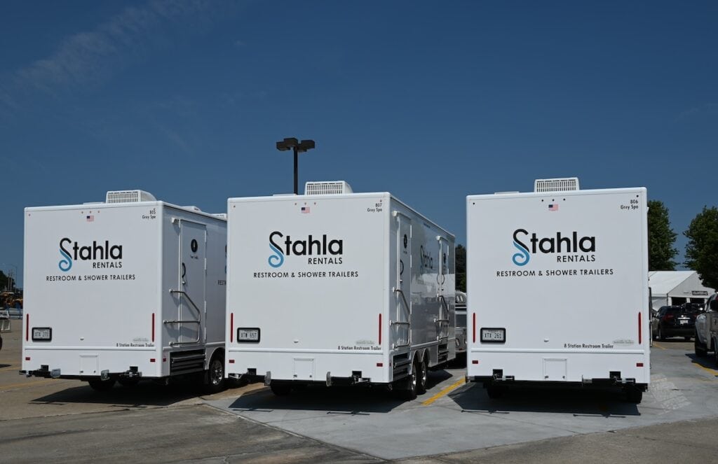 Three Stahla restroom and shower trailers parked outdoors.
