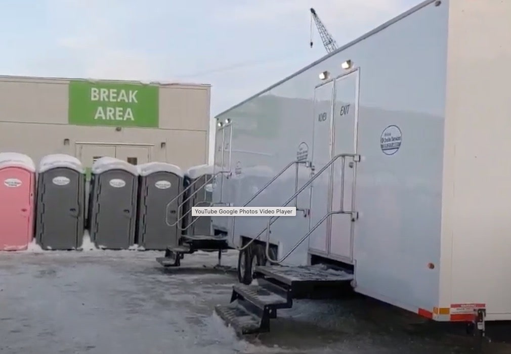 Portable toilets by workplace break area with snow.