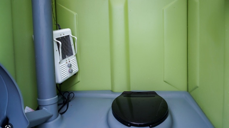 Portable toilet interior with hand sanitizer dispenser.