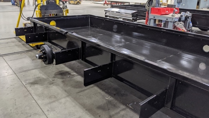 Industrial trailer chassis in manufacturing facility.