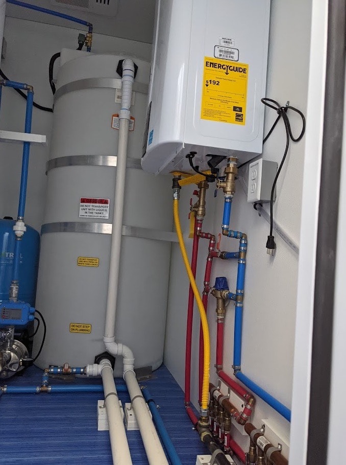 Water heaters and pipes in utility closet.