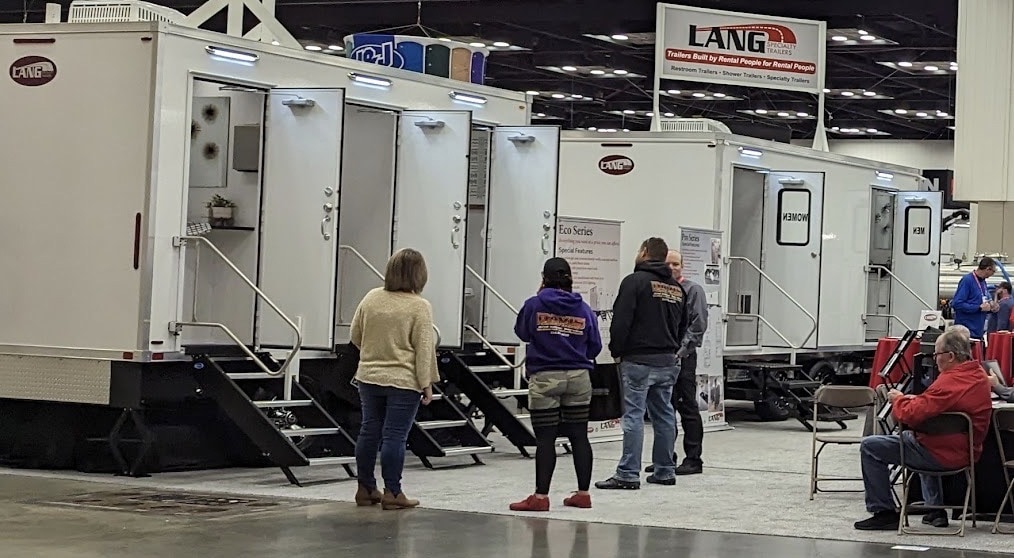 Portable restroom trailers at an indoor expo.