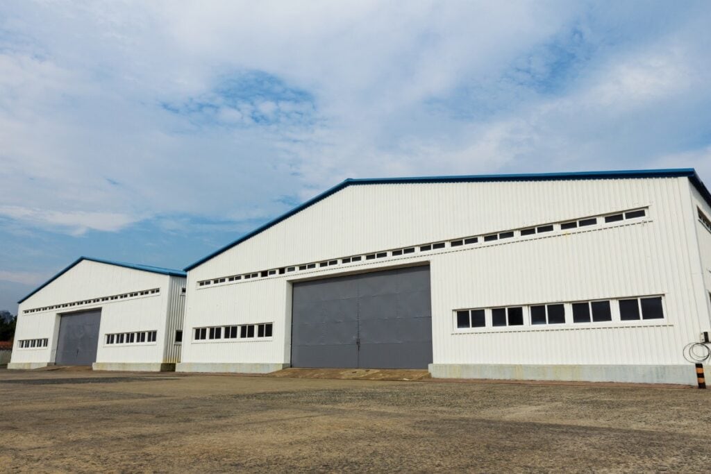 Industrial warehouses with large doors under blue sky.