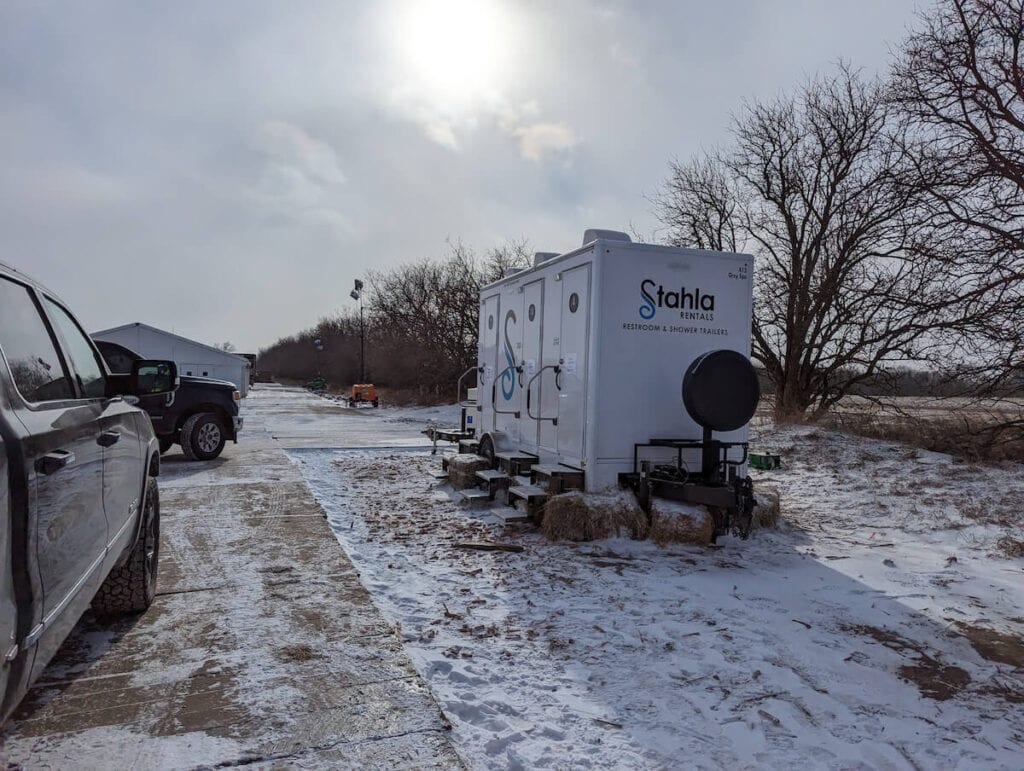Image 7: Mobile restroom trailer parked in snowy lot.