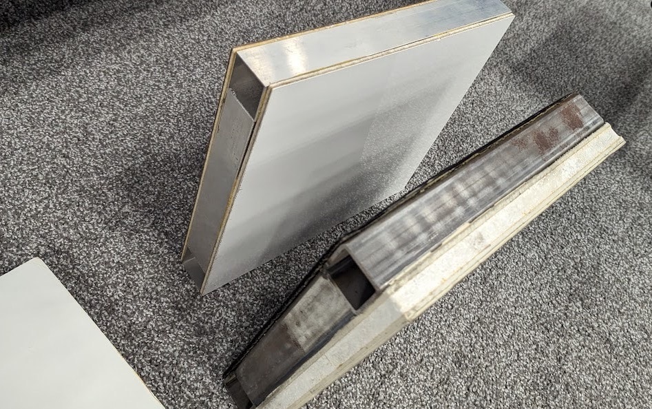 Steel and aluminum angle profiles on carpet.