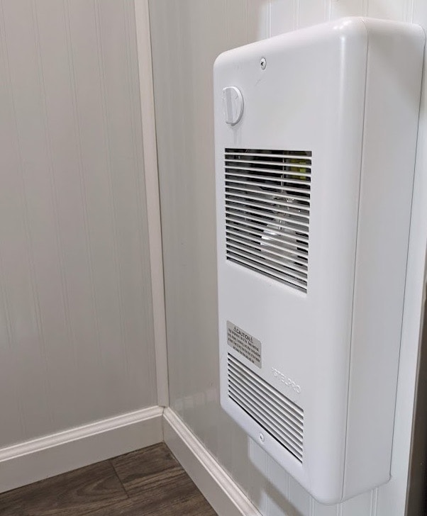 White wall-mounted electric heater in a room.