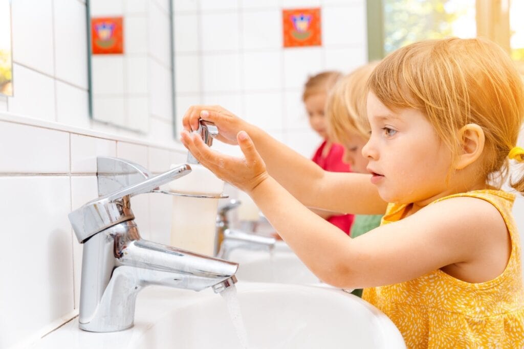 Children washing hands at school sink.