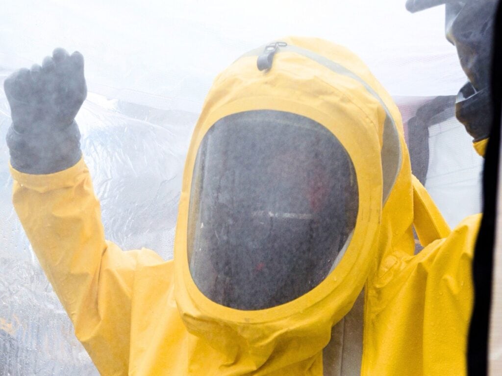 Person in yellow hazmat suit with obscured face