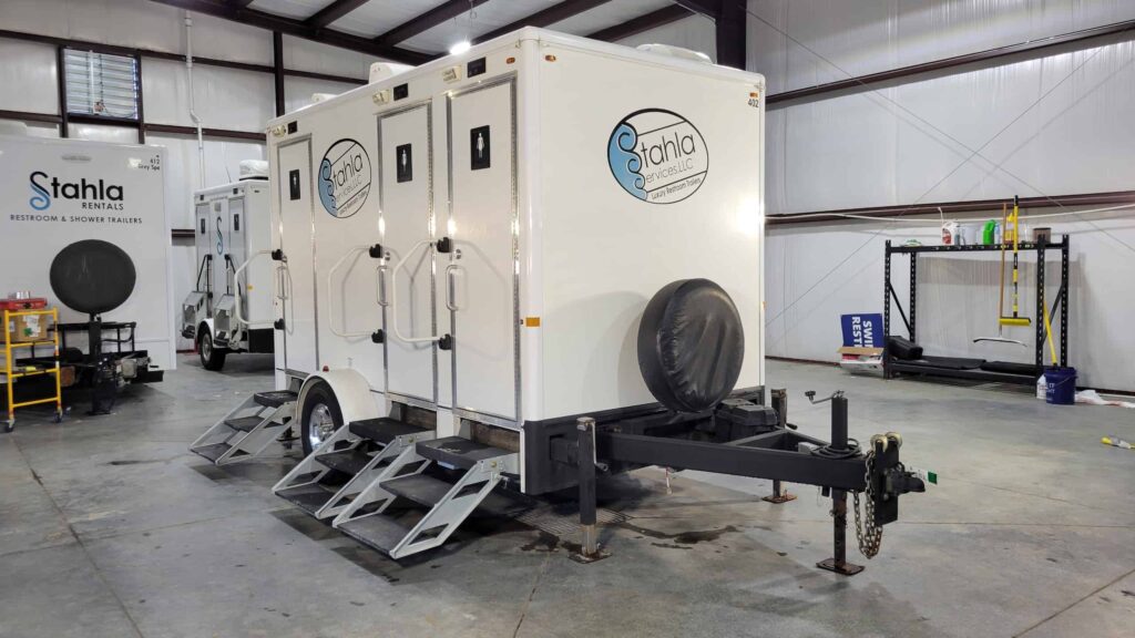 Mobile luxury restroom trailer inside warehouse.