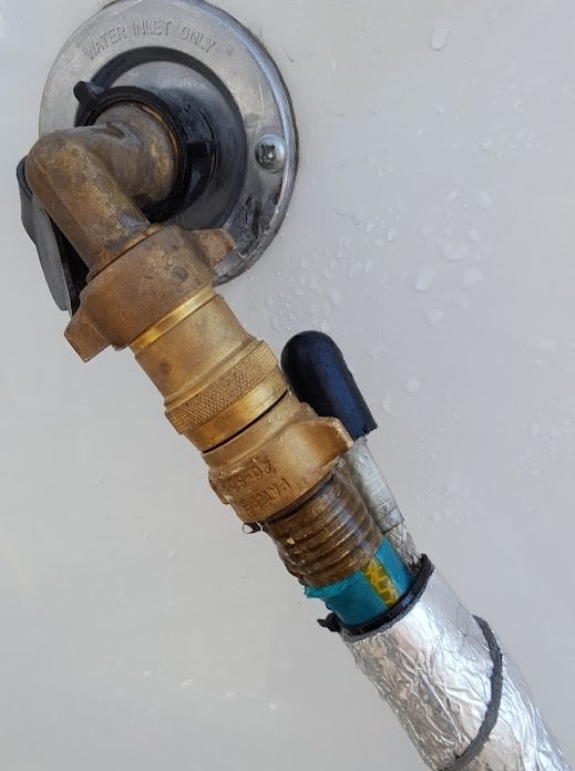 Outdoor water spigot leaking with hose attached.