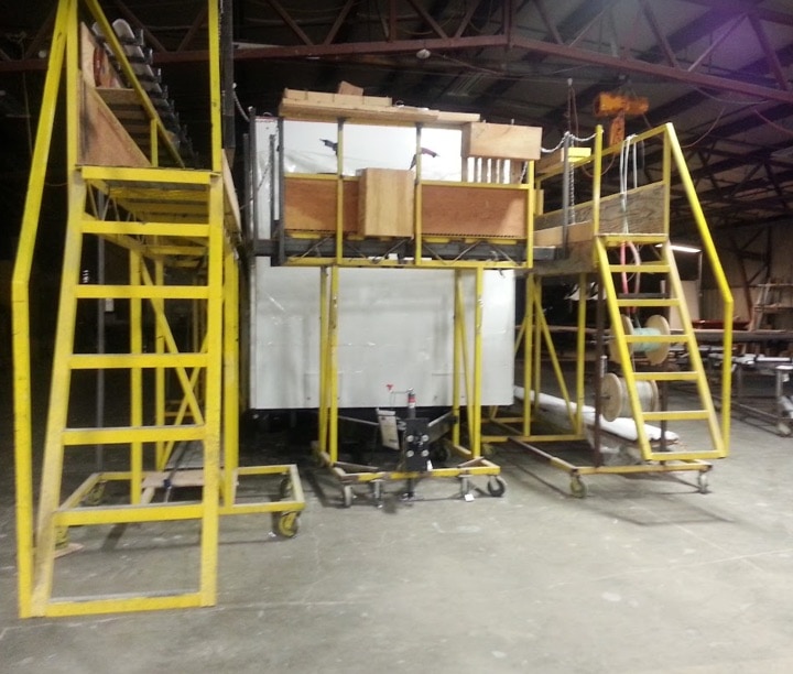 Industrial warehouse with yellow stairs and equipment.