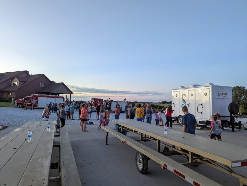 Outdoor community event near mobile restroom facility.