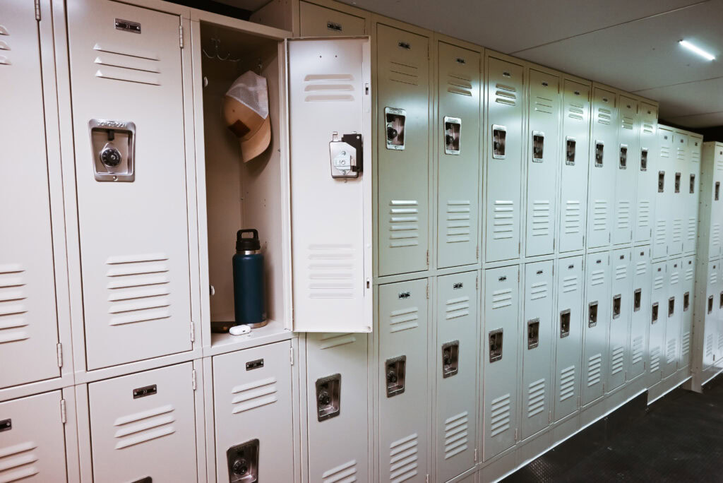 A row of beige lockers, with one locker door open showing a hat and a water bottle inside—demonstrating the commitment to excellence that defines Stahla Services.