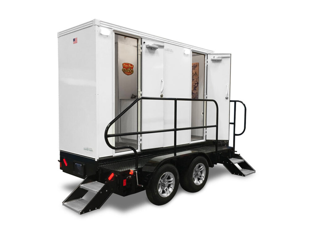 Mobile restroom trailer on wheels with steps.