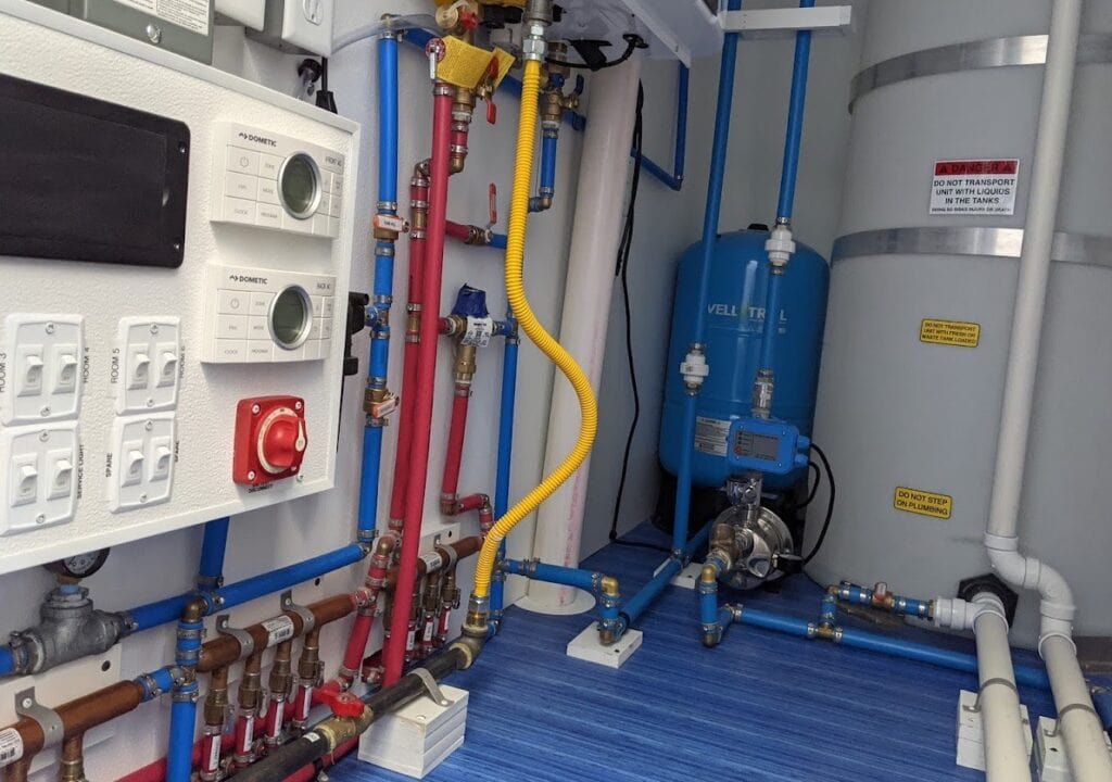 Industrial water filtration system room with pipes and tanks.